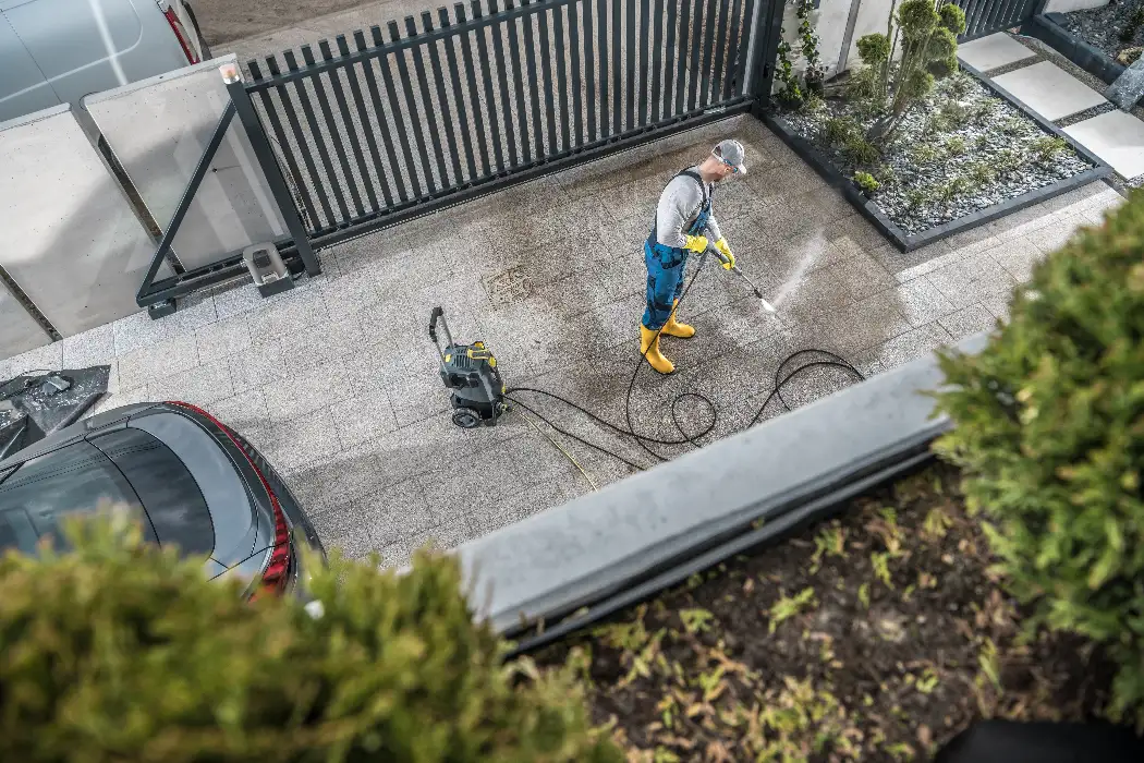 Technician pressure washing a residential paver driveway in Orlando with professional equipment
