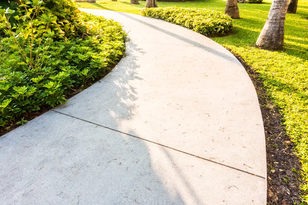 Concrete walkway winding through Orlando home landscaping with clean finished surface